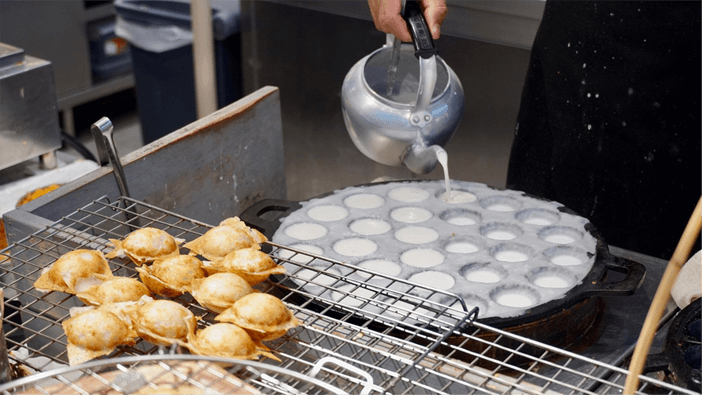 Coconut Pancakes on the street, Bangkok - Photo by Joe Wheaton cooking